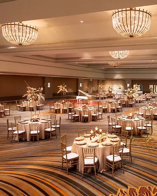 Gold chiavari chairs in a grand hotel ballroom with chandeliers